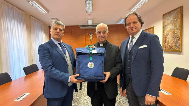 monsignor rino fisichella con lo zaino del pellegrino per il giubileo 2025